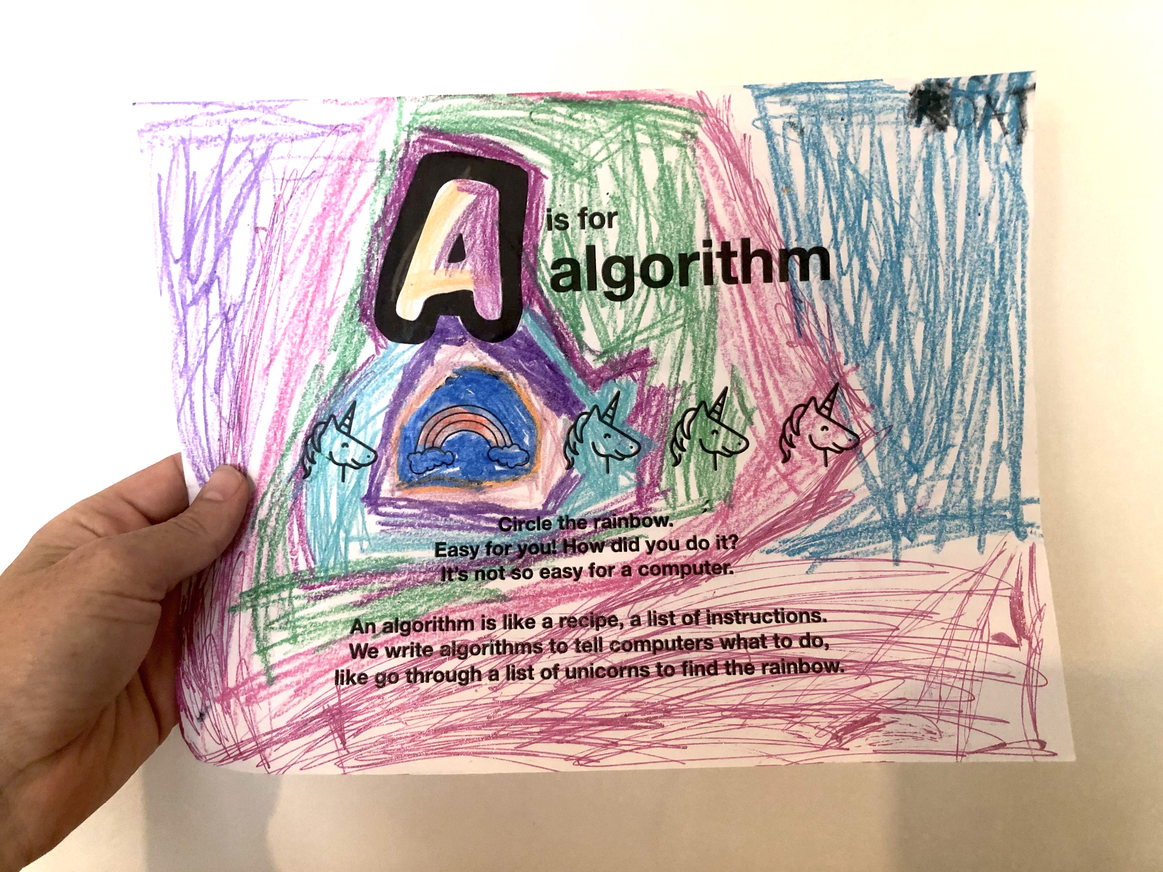 Hand holding a colored A is for algorithm coloring book page.