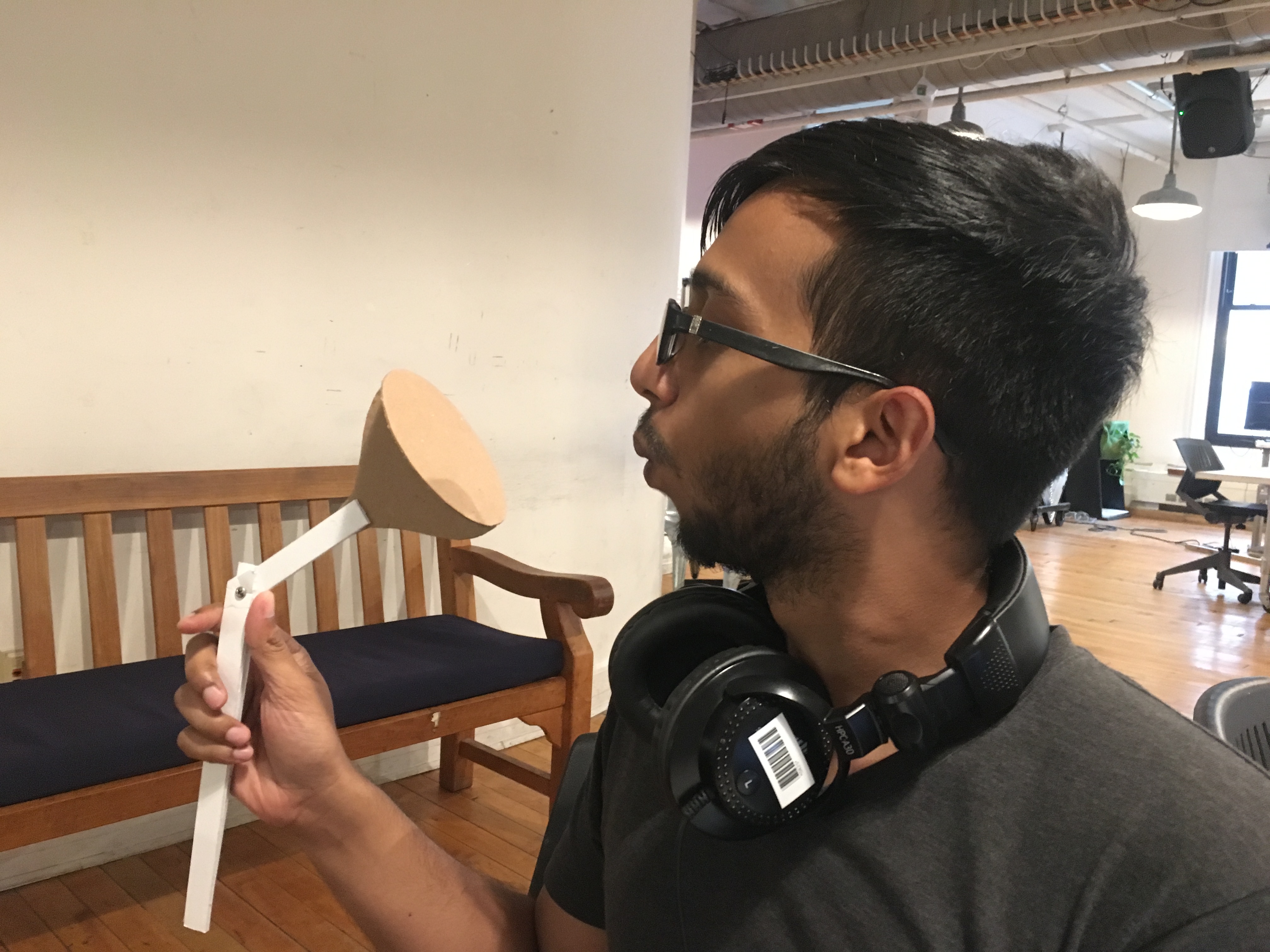 young man blowing into a prototype of an air funnel