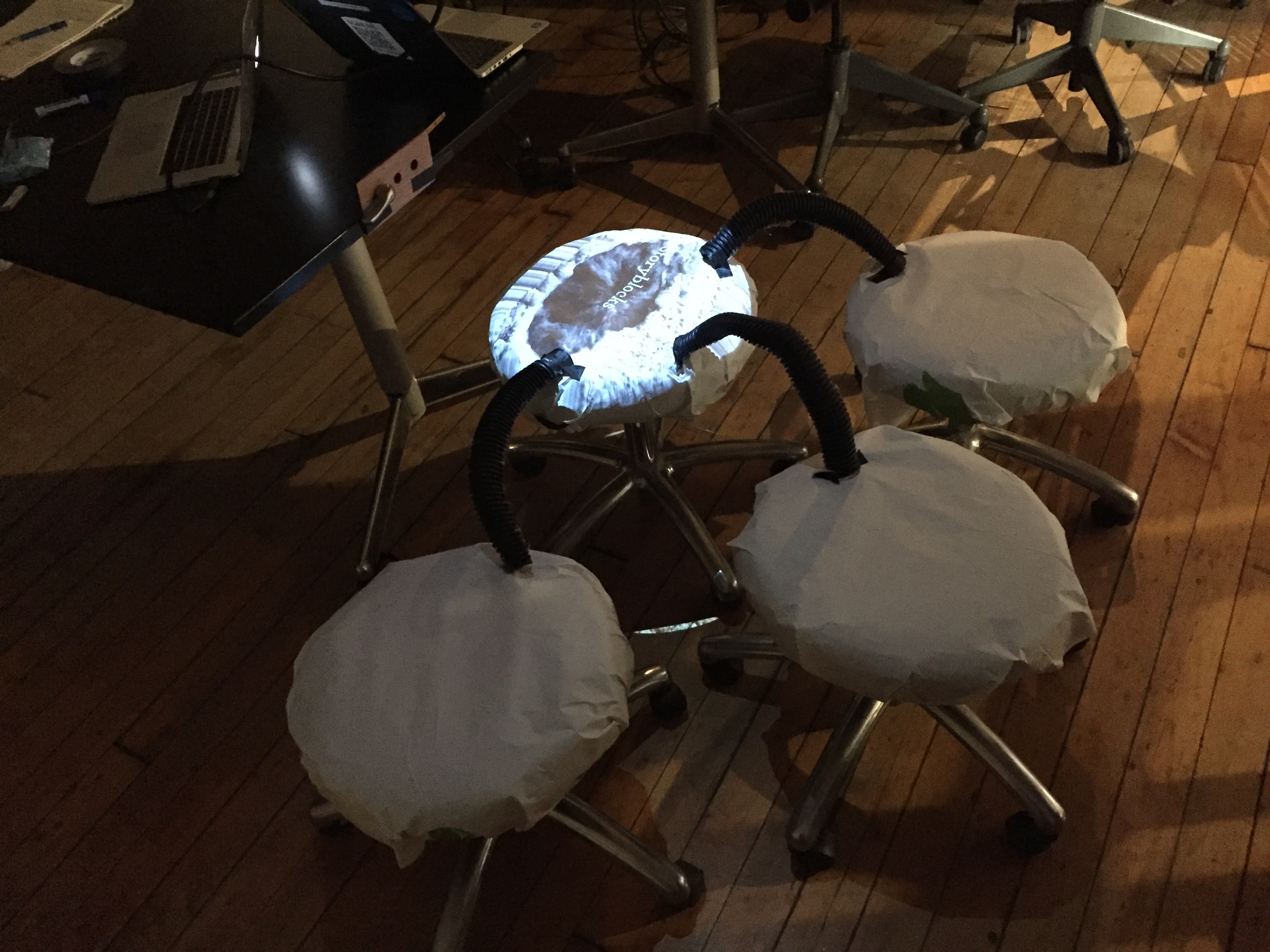 images being projected onto four stools that represent sludge and three different ways in which it can be transformed