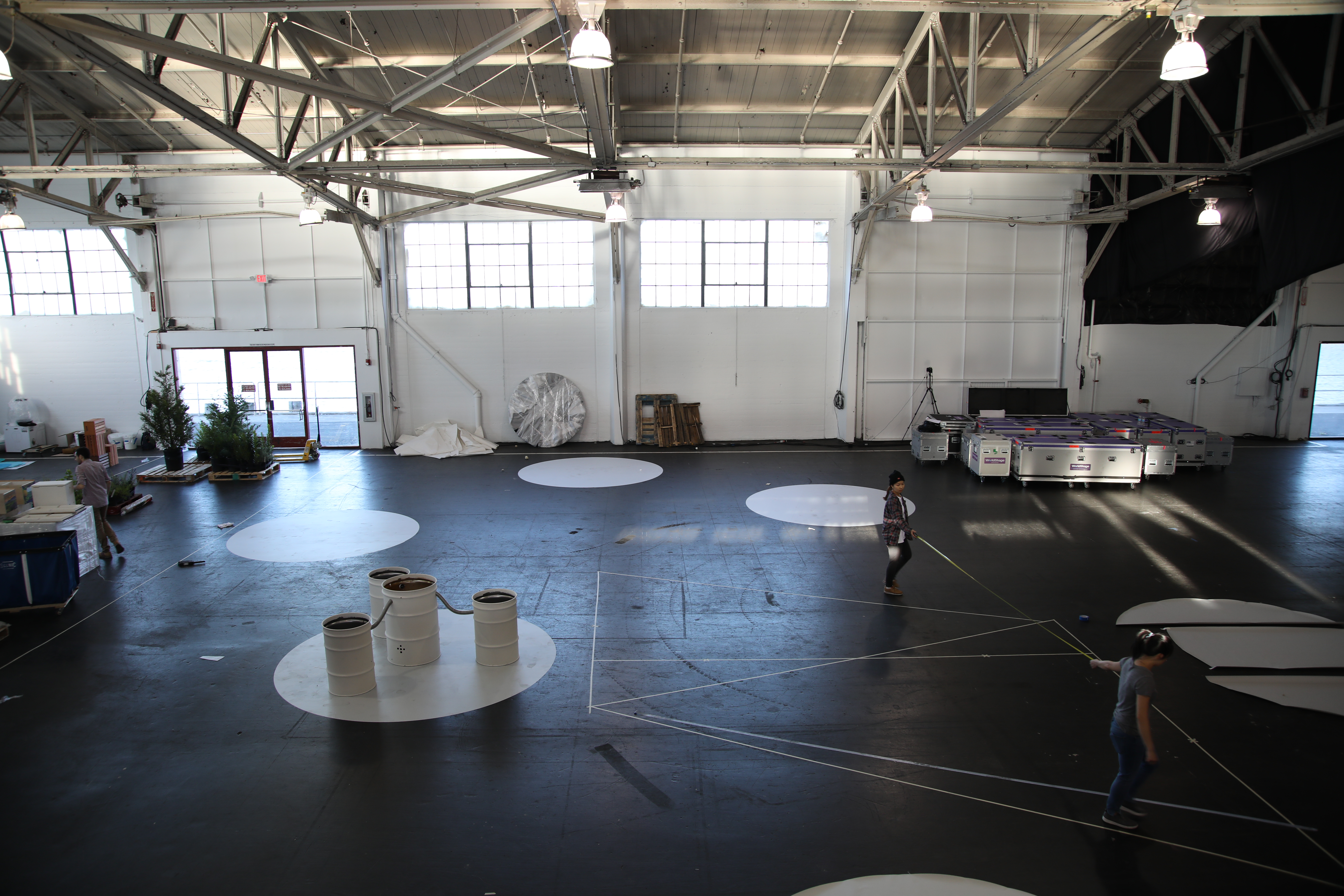 Photo of a warehouse space with materials and tables all over it