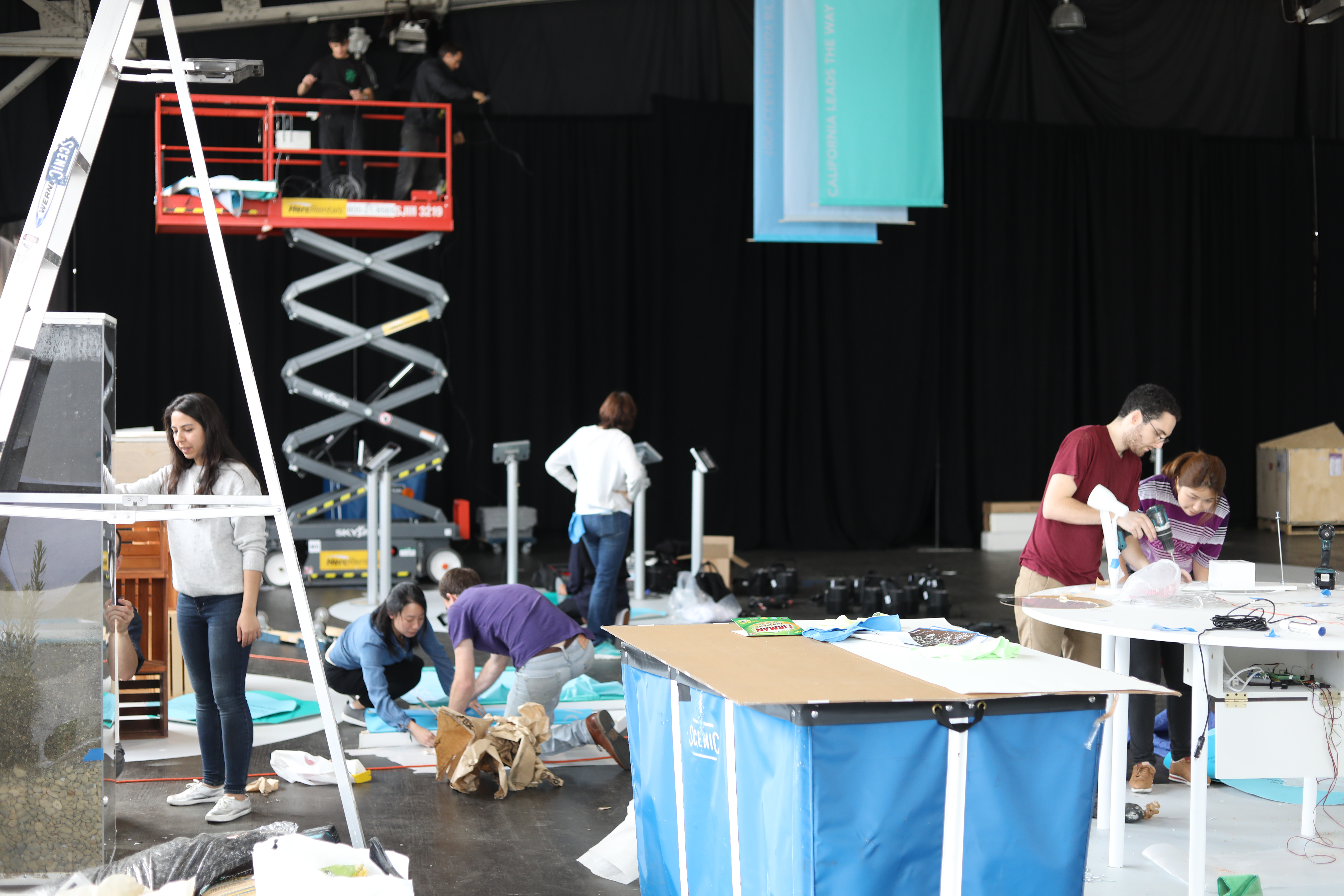 photo of a large group of people working on different projects in a warehouse space